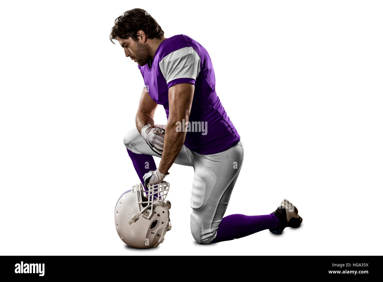 Football Player with a purple uniform on his knees, on a white
