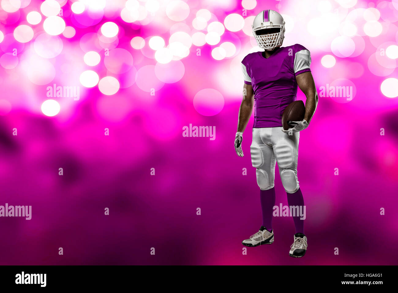 Football Player with a pink uniform on a pink lights background Stock