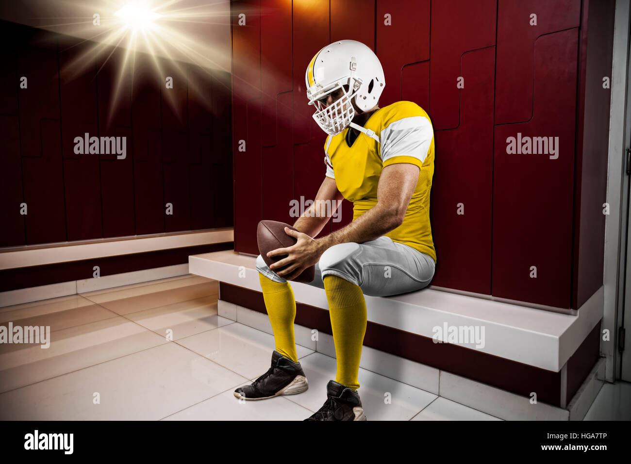 Football Player with a yellow uniform seated in locker room Stock Photo Alamy
