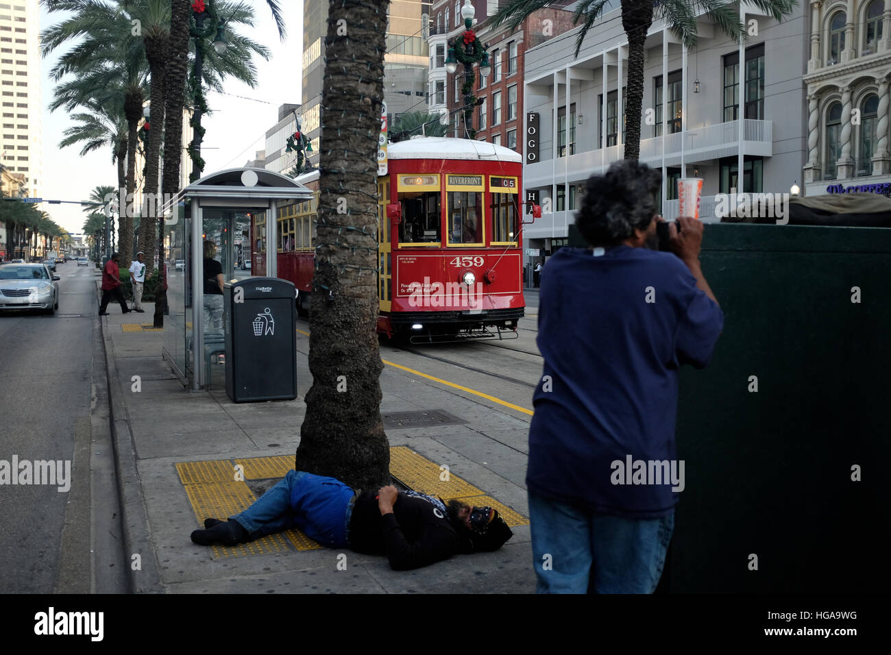 NEW ORLEANS, LA: Two homeless men loiter on Canal Street in the French Quarter as a streetcar approaches.  11/15/16 Stock Photo