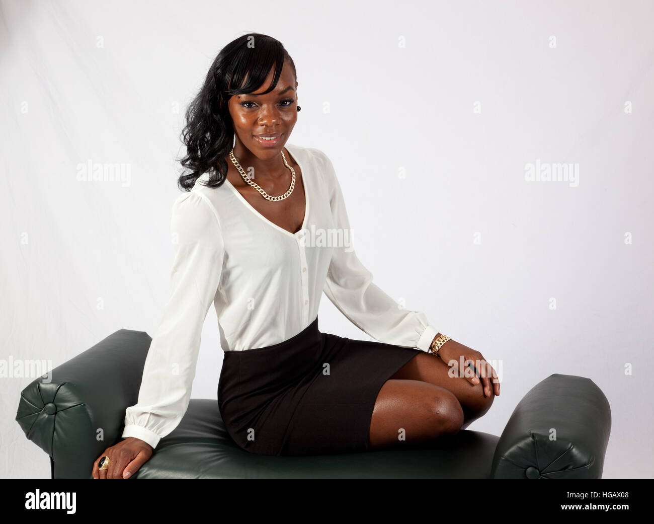 Pretty black woman in a dress sitting and smiling at the camera Stock ...