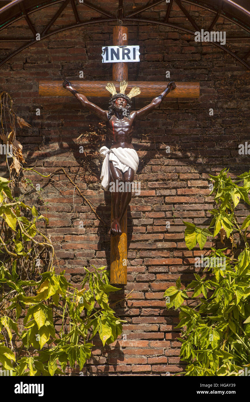 A crucified Black Jesus Christ statue stands in a brick grotto at the Bantay Church in Ilocos Sur, Luzon Island, Philippines. Stock Photo
