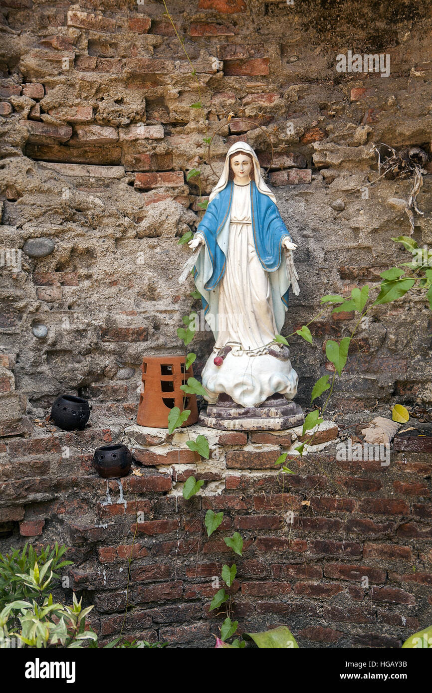 A statue of the Blessed Virgin Mary stands in the ruins of an old Spanish church at Bantay, Luzon Island, Philippines. Stock Photo