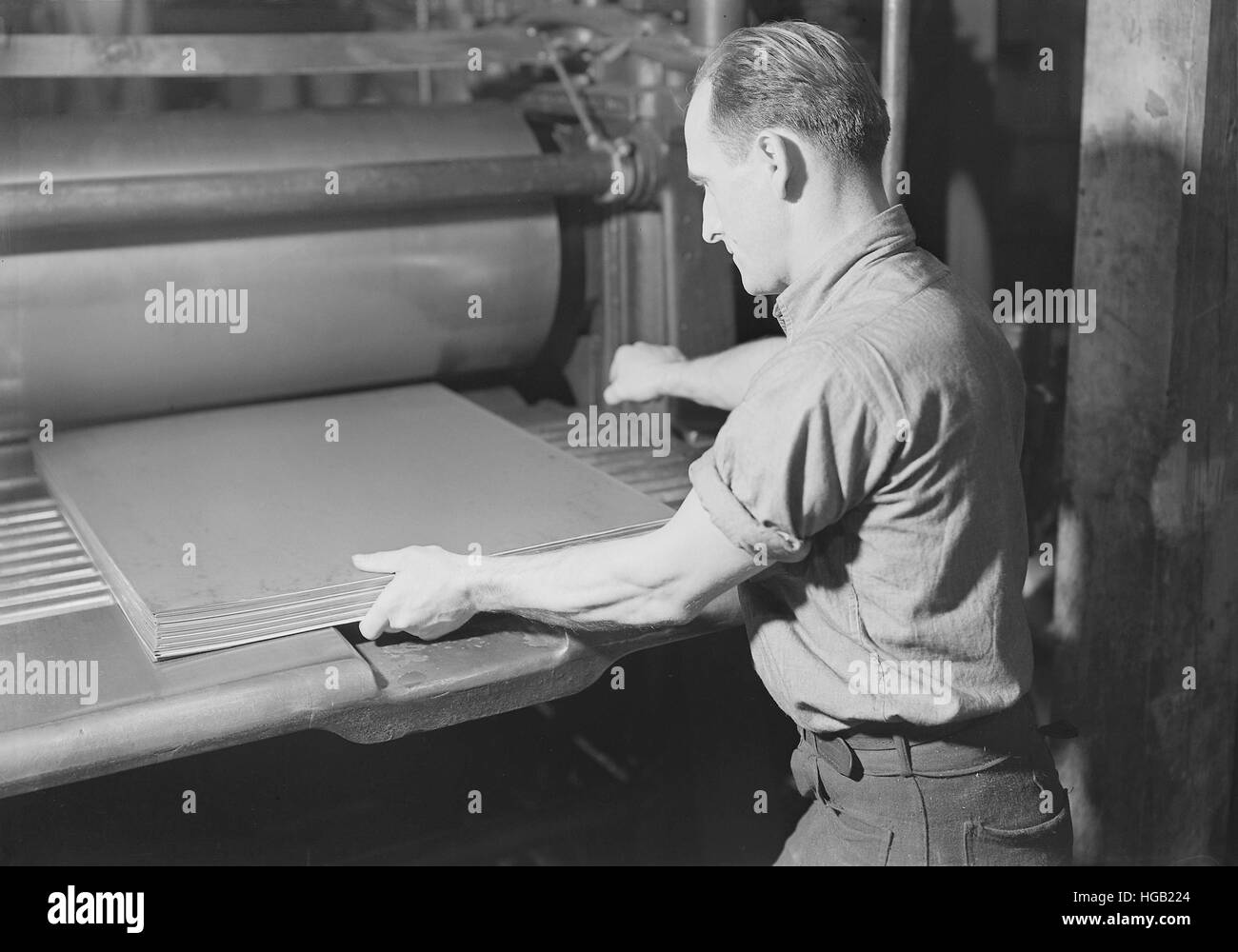 Man pressing paper at the American Writing Paper Co., 1936 Stock Photo