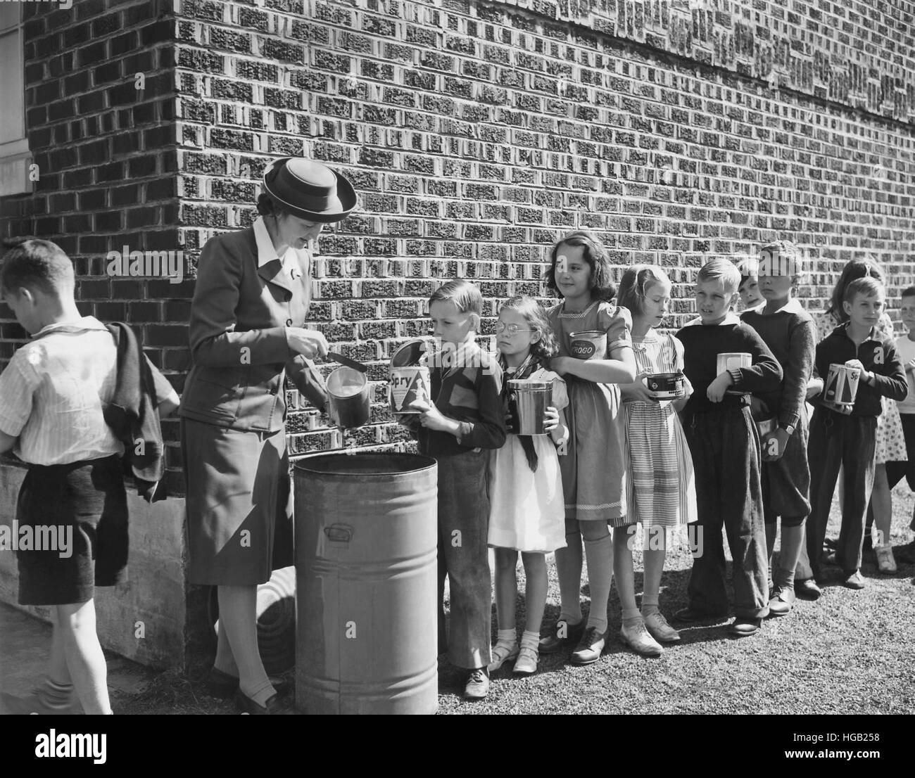 Boys and girls collect fats and greases then turn it over to school authorities. circa 1942 Stock Photo