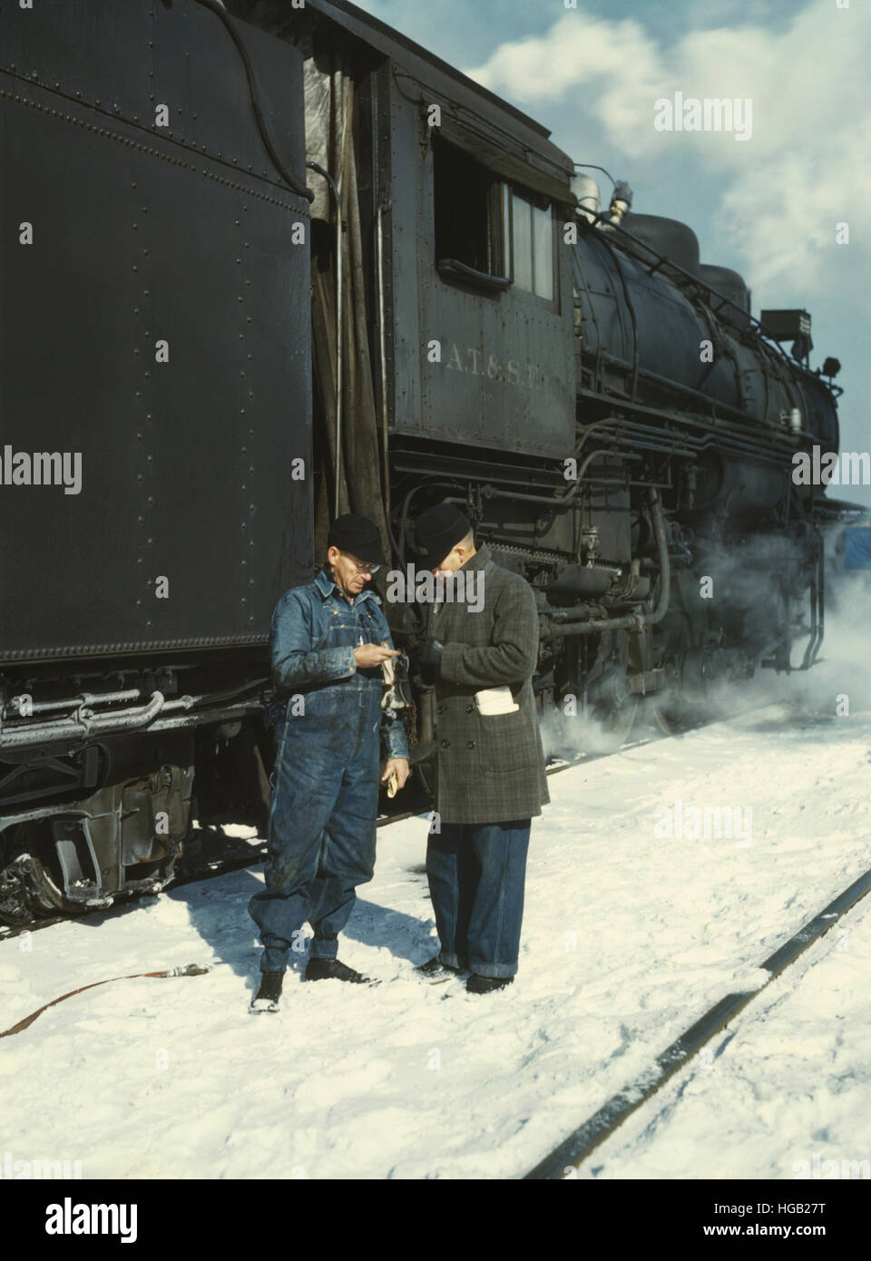 Railroad conductors comparing time before pulling out of railroad yard. Stock Photo