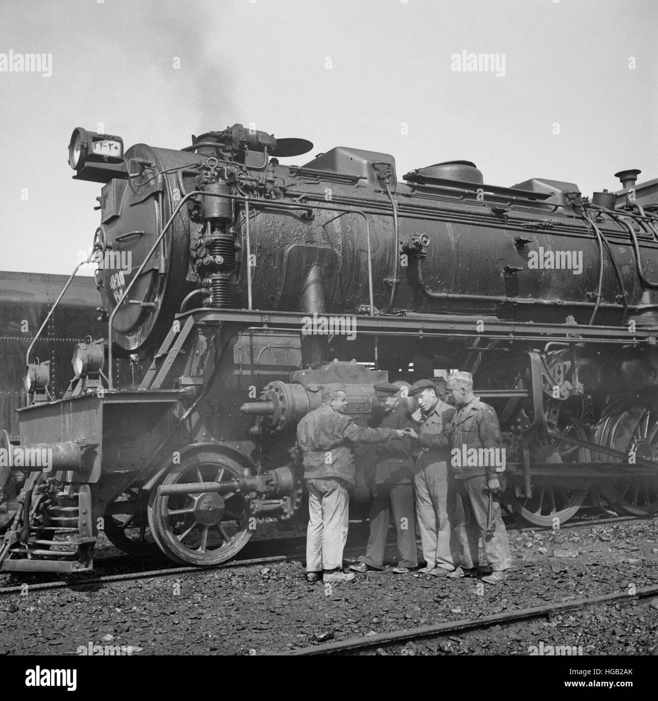 American and Russian railroad engineers are examining one of the German-made engines, 1943. Stock Photo