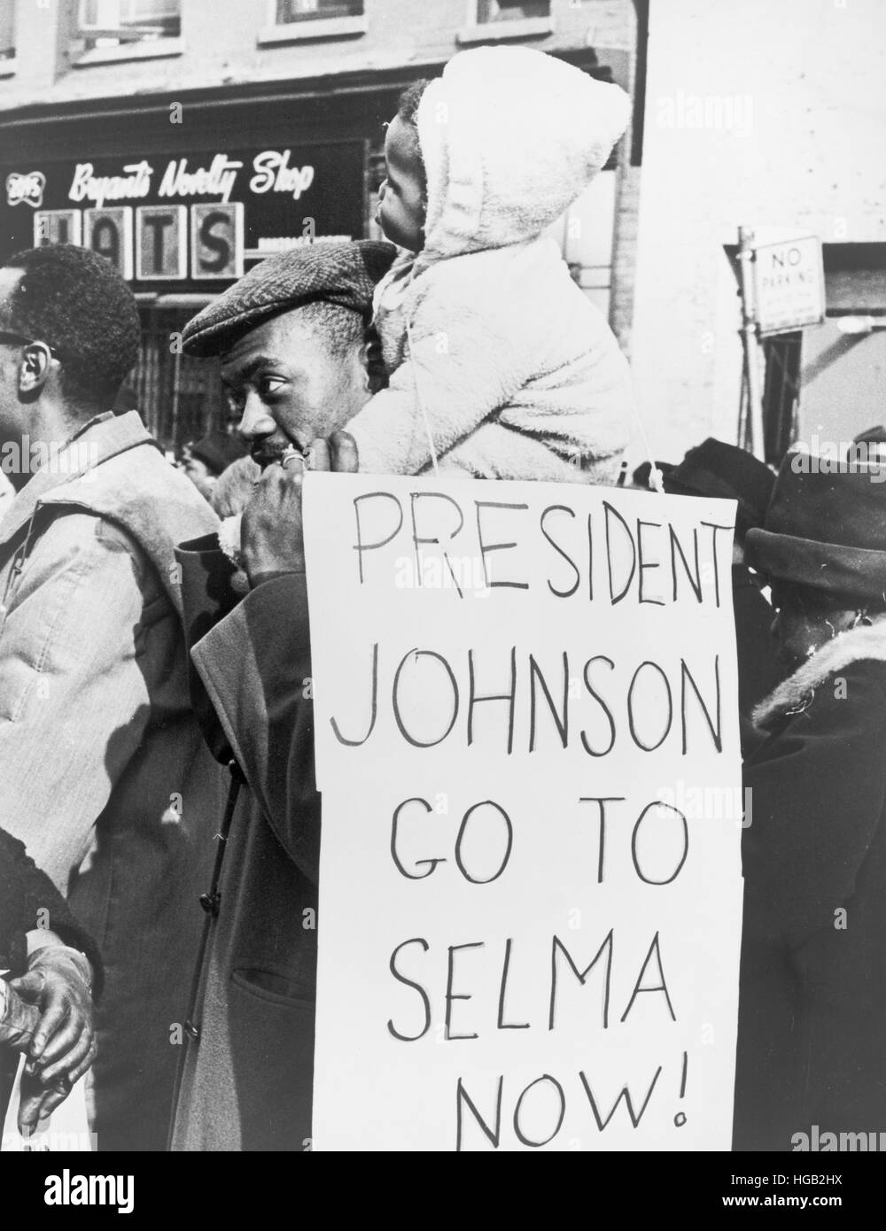 An African American man carrying a child with placard druing Selma march in 1965. Stock Photo