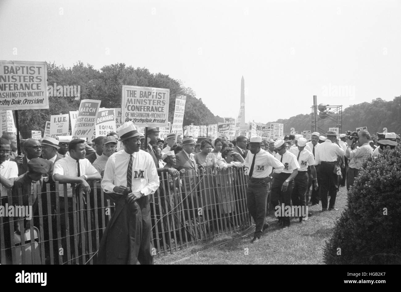 Marshals standing by fence near crowd carrying signs during the March on Washington, 1963 Stock Photo