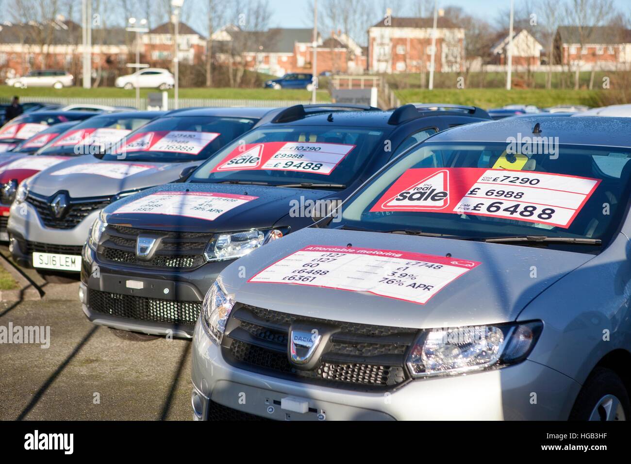 Dacia Discounted vehicles, second hand saloon cars lined up on used car garage forecourt with APR 'real sale' deal stickers, Preston, Lancashire, UK. Stock Photo