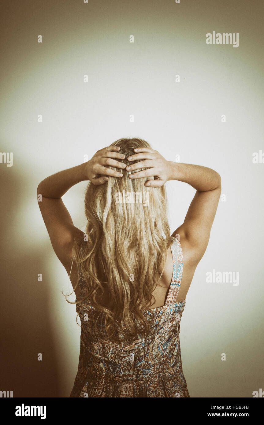 Rear view of a woman hands on head Stock Photo - Alamy