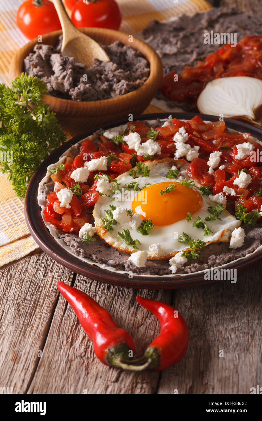 Mexican breakfast: huevos rancheros close-up on a plate on the table. vertical Stock Photo