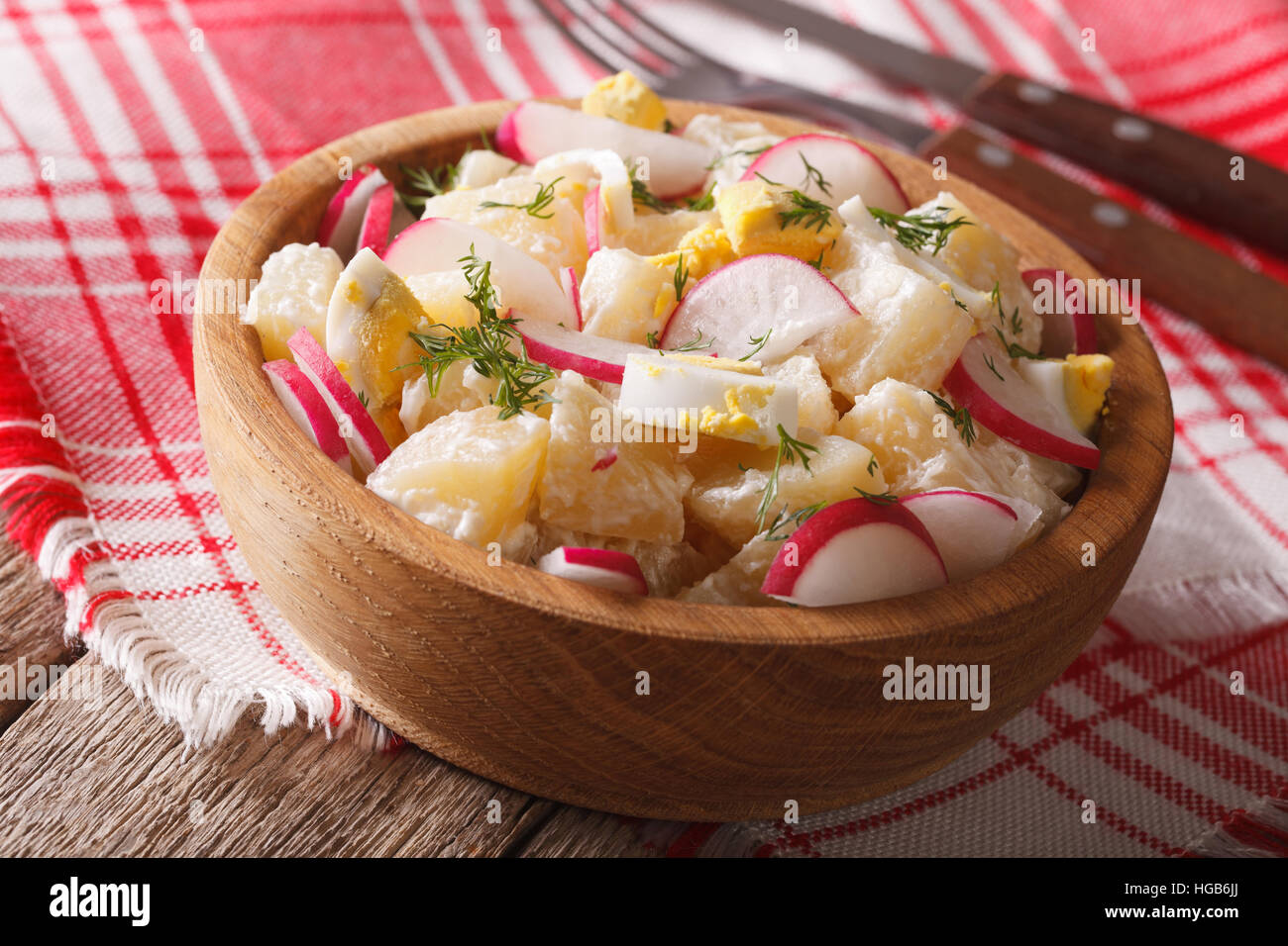 Homemade potato salad with radish and eggs close-up in a bowl on the table. horizontal Stock Photo