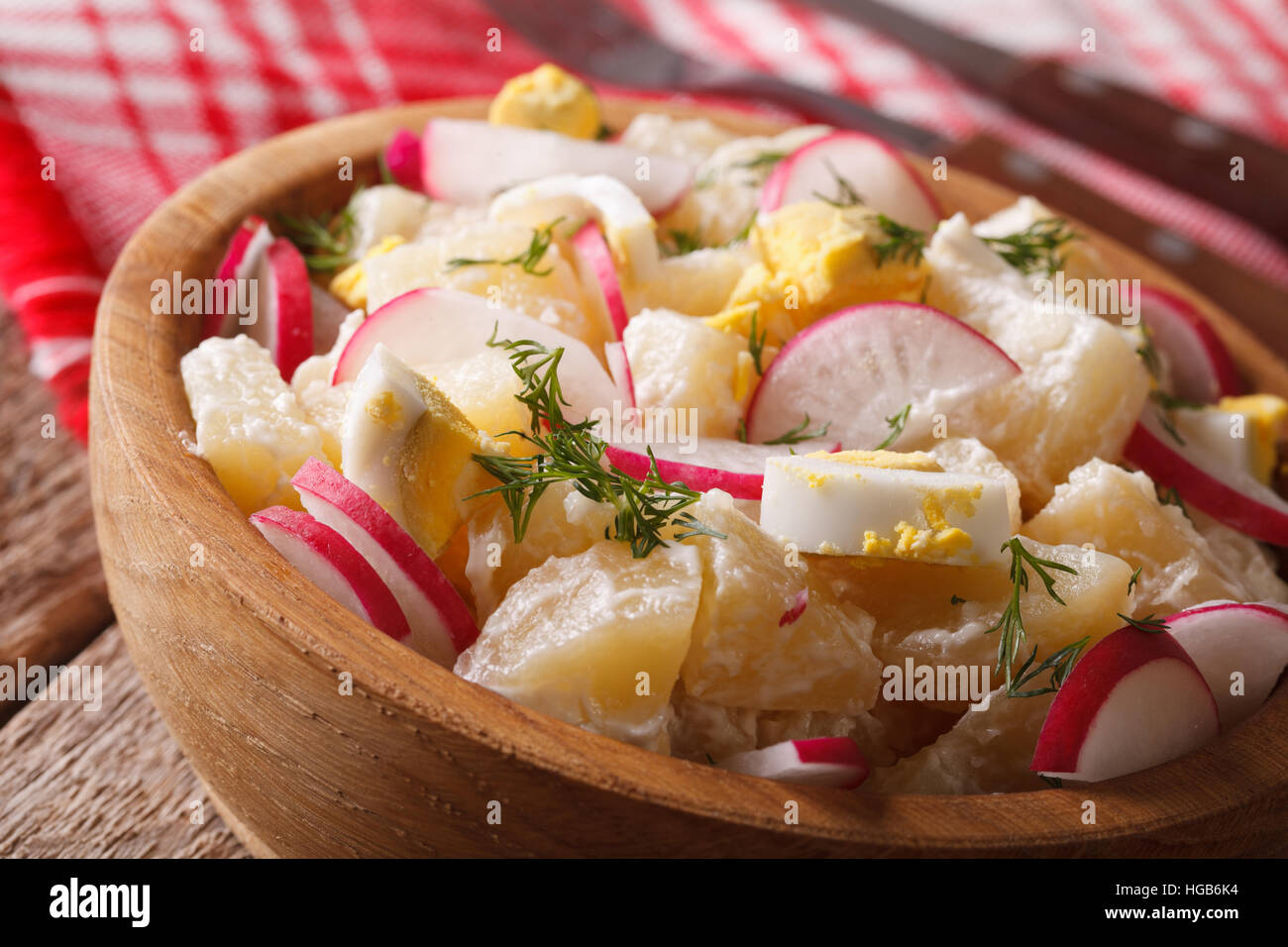potato salad with radish and eggs close-up on a plate on the table. horizontal Stock Photo
