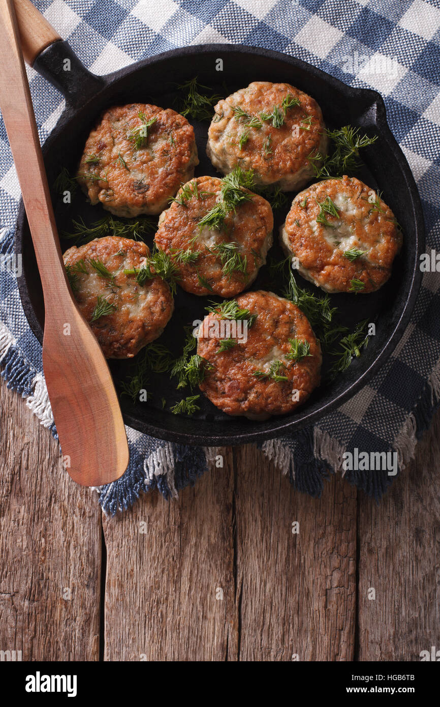 fish cakes with herbs closeup in a frying pan. vertical top view Stock