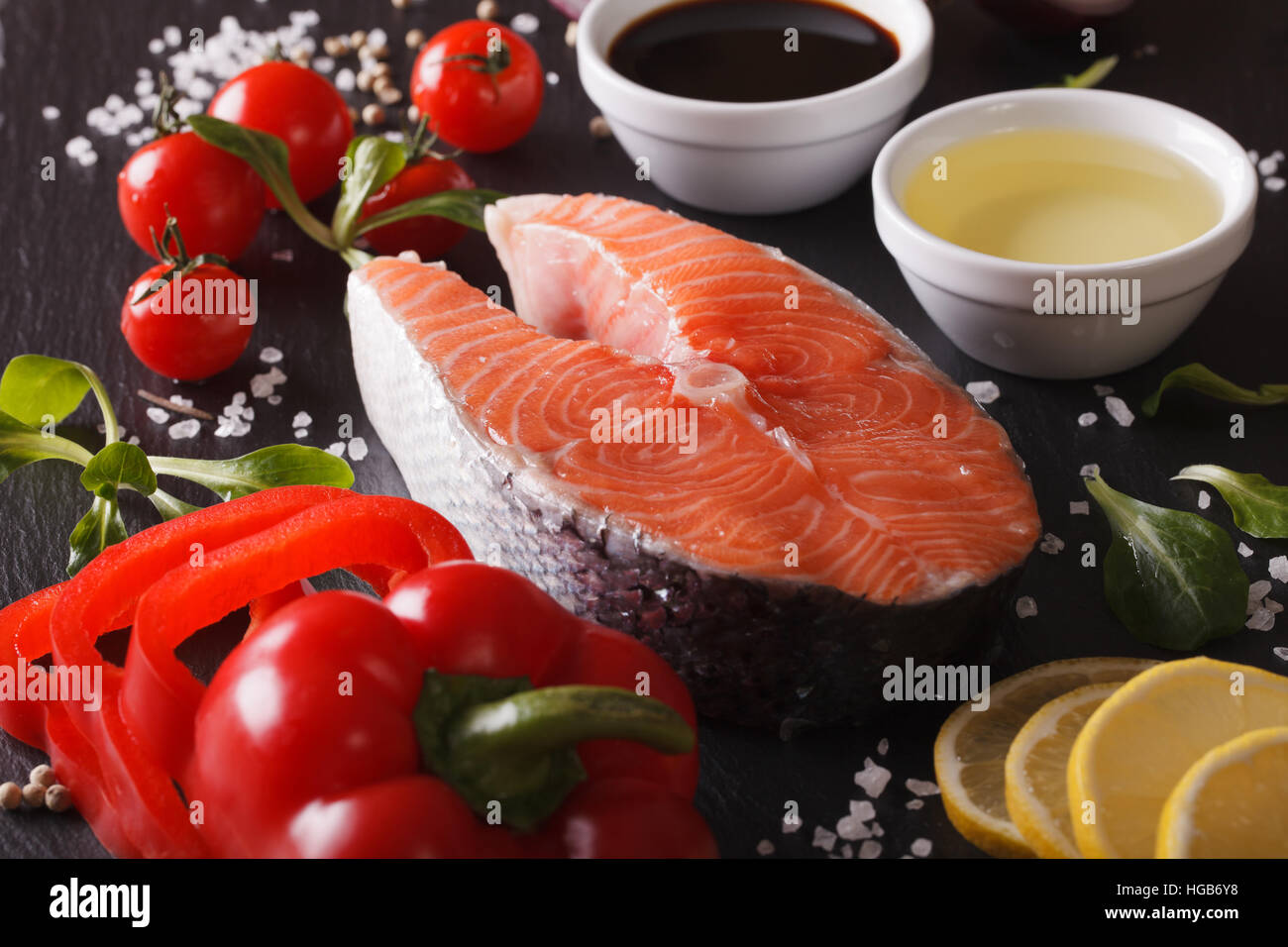 Raw salmon steak and ingredients on a slate board macro. horizontal ...