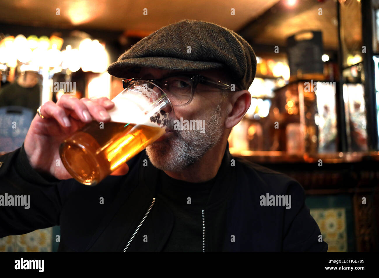 Man drinking pint bitter flat cap Yorkshireman pub Stock Photo