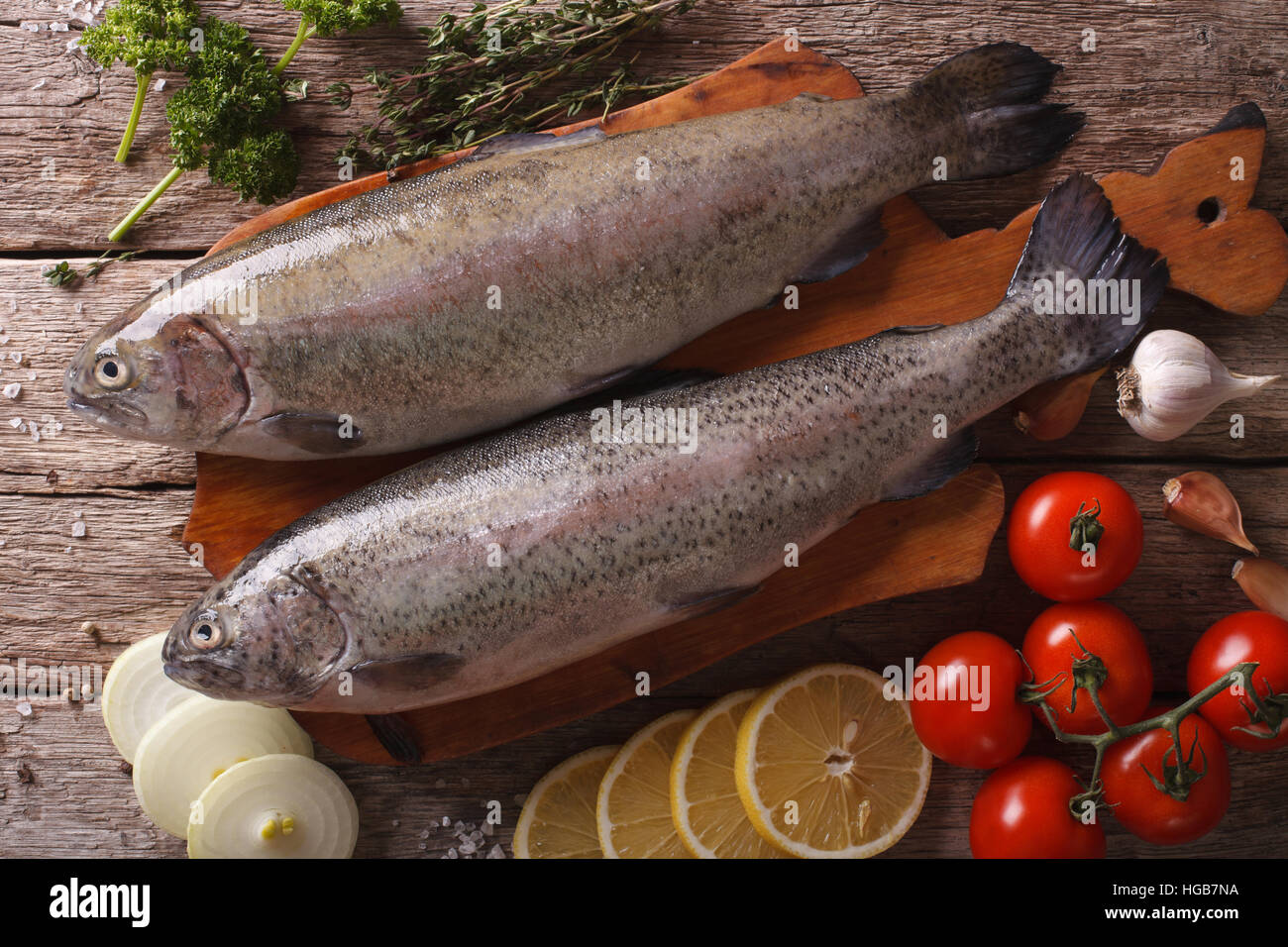 raw rainbow trout with ingredients on a wooden table close-up. Horizontal top view Stock Photo