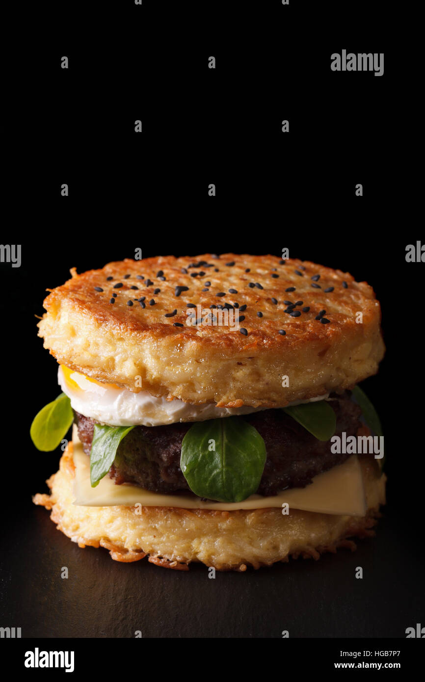 New ramen burger with beef and eggs closeup on a black background