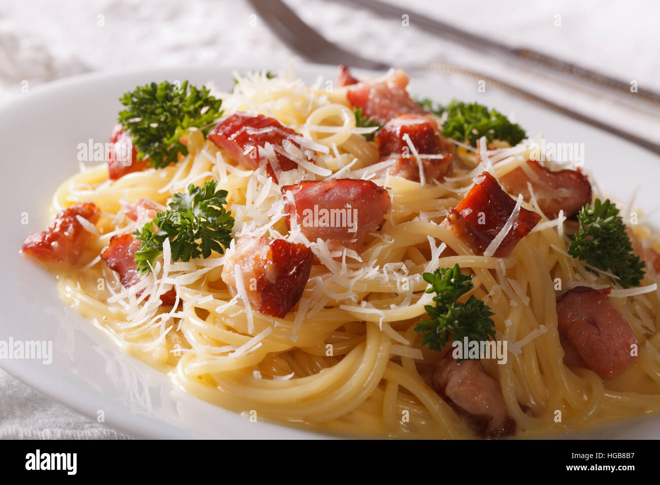 pasta carbonara with bacon and parmesan close-up on a plate. horizontal Stock Photo