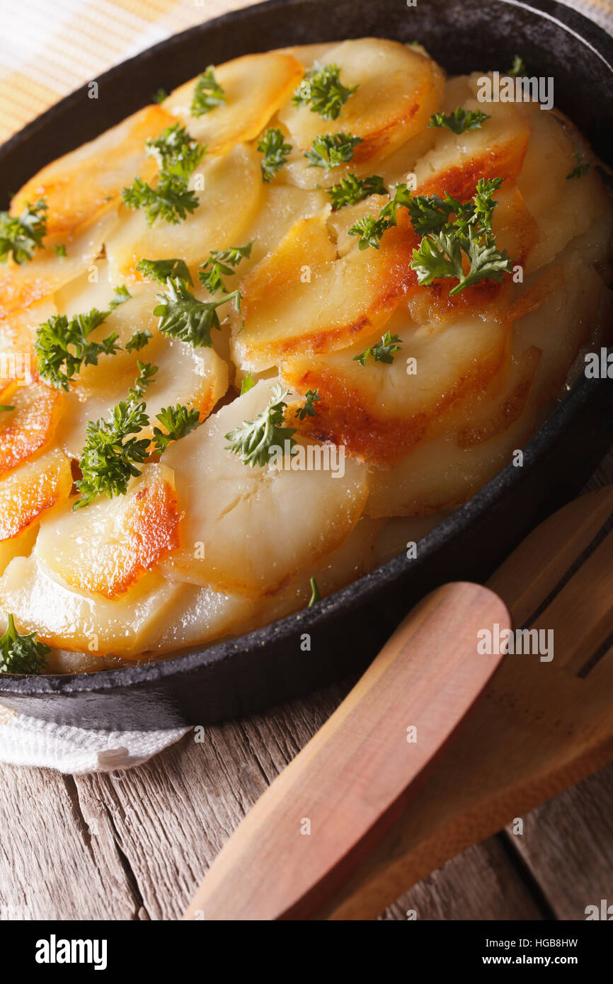 Delicious potato casserole in a pan close-up on the table. vertical Stock Photo