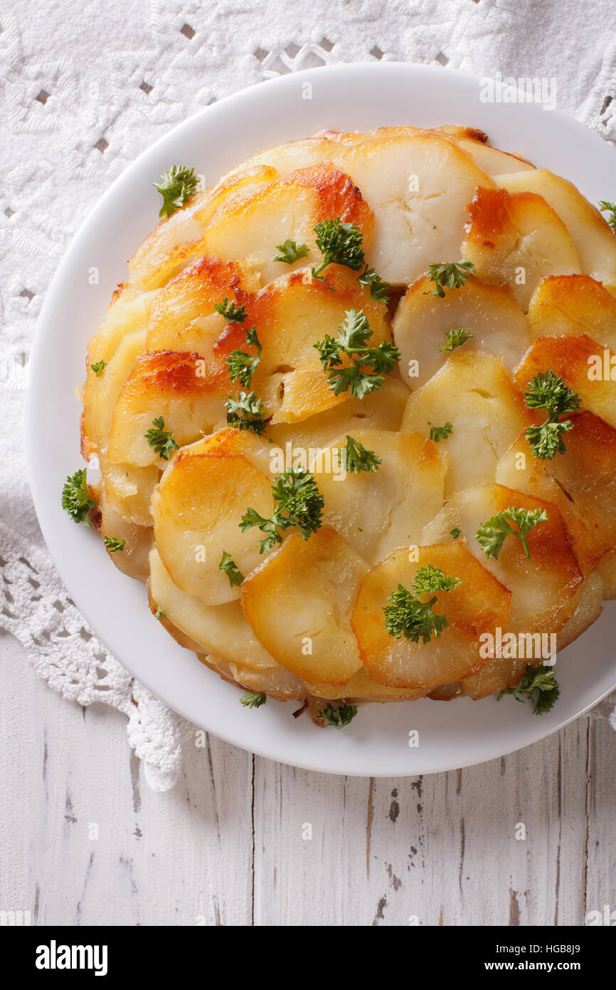 Potato casserole with butter on a white plate closeup. Vertical top view Stock Photo