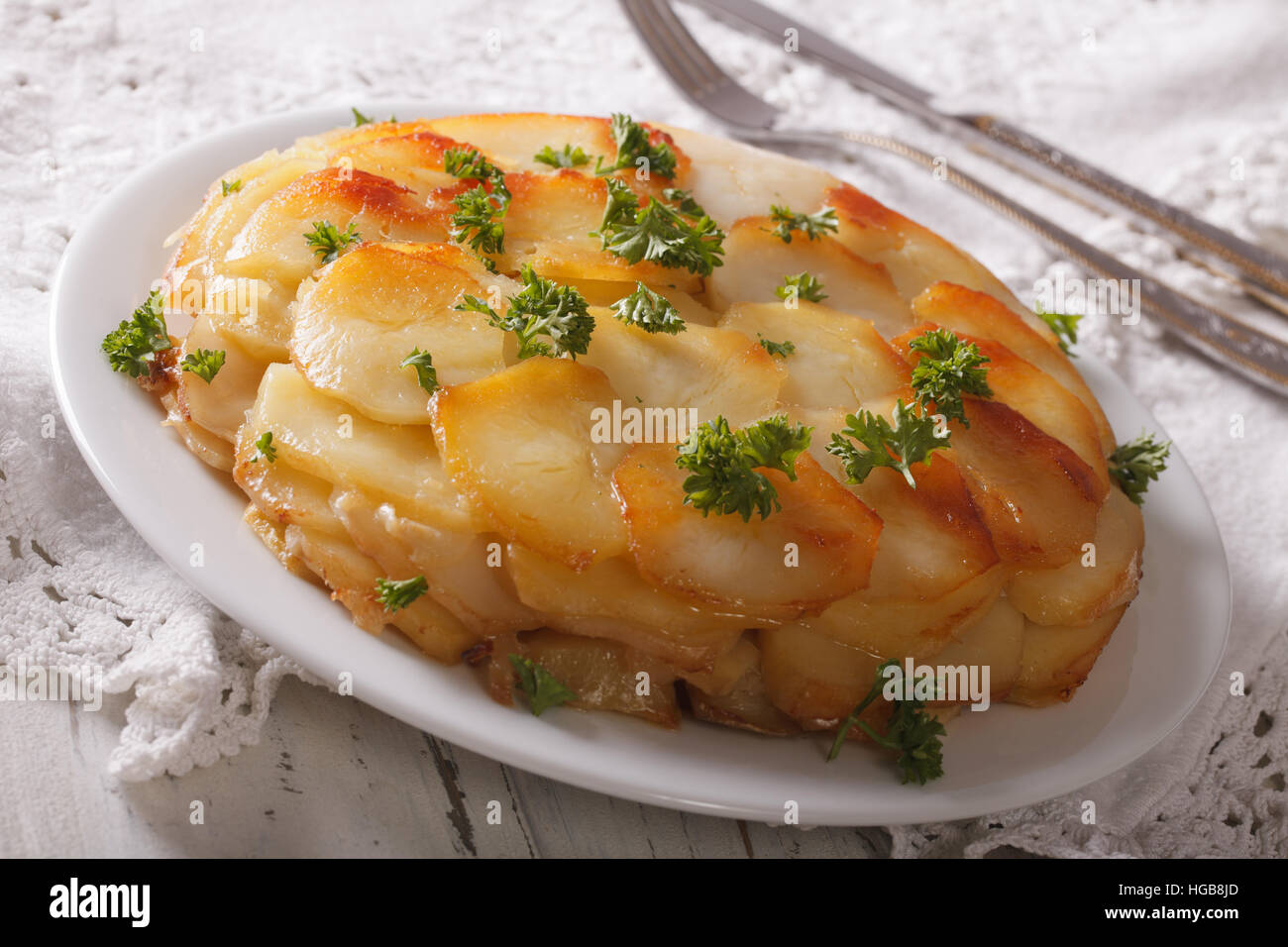 Potato casserole with butter on a white plate closeup on the table. horizontal Stock Photo