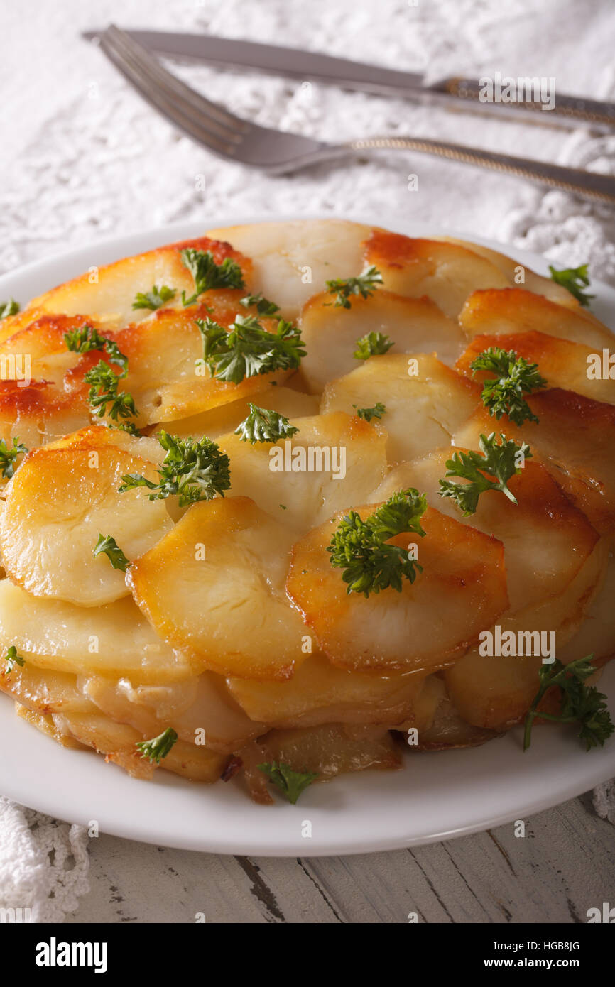 Potato casserole with butter on a white plate closeup on the table. vertical Stock Photo