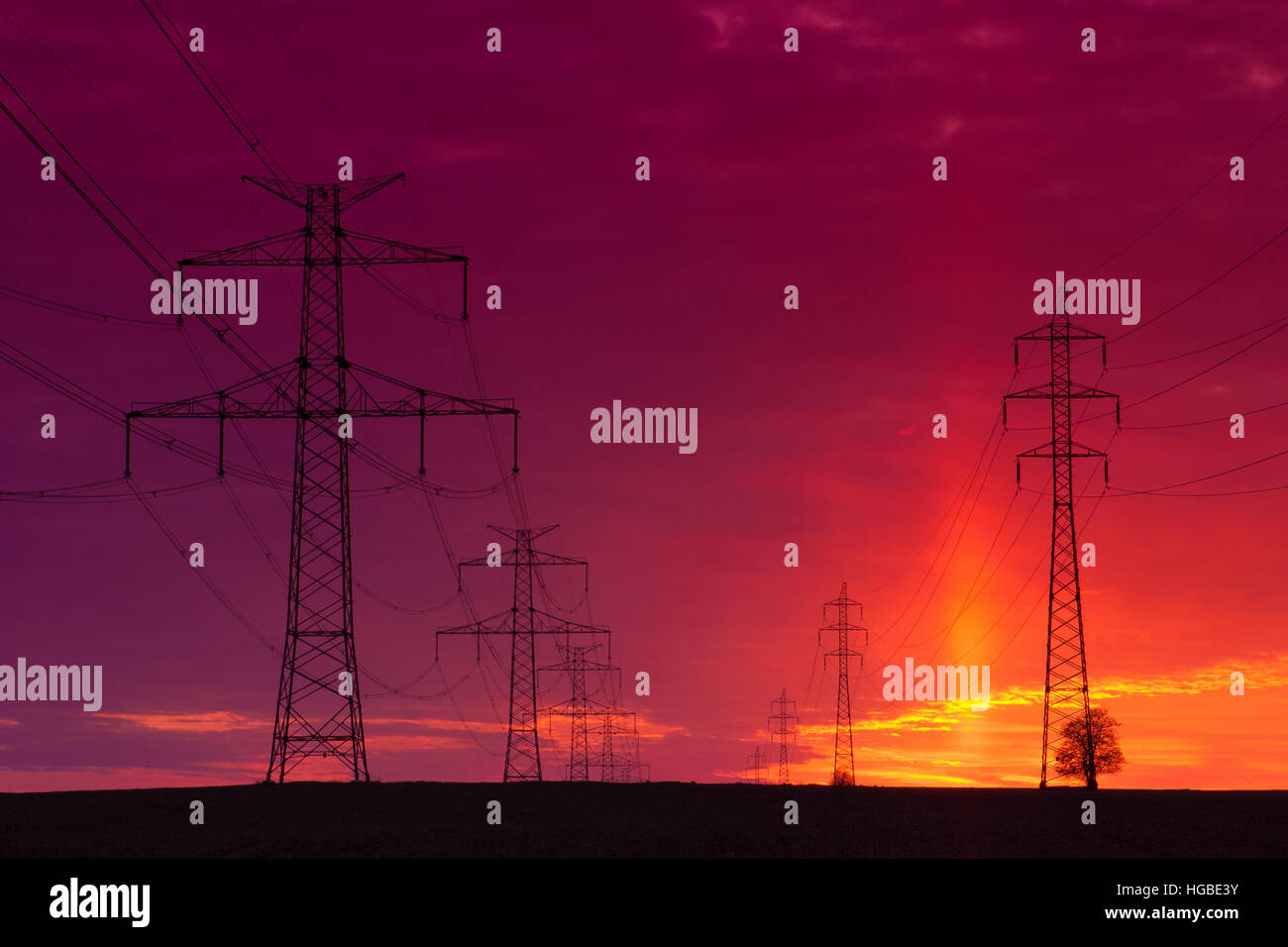 Transmission towers on the field at red sunset Stock Photo - Alamy