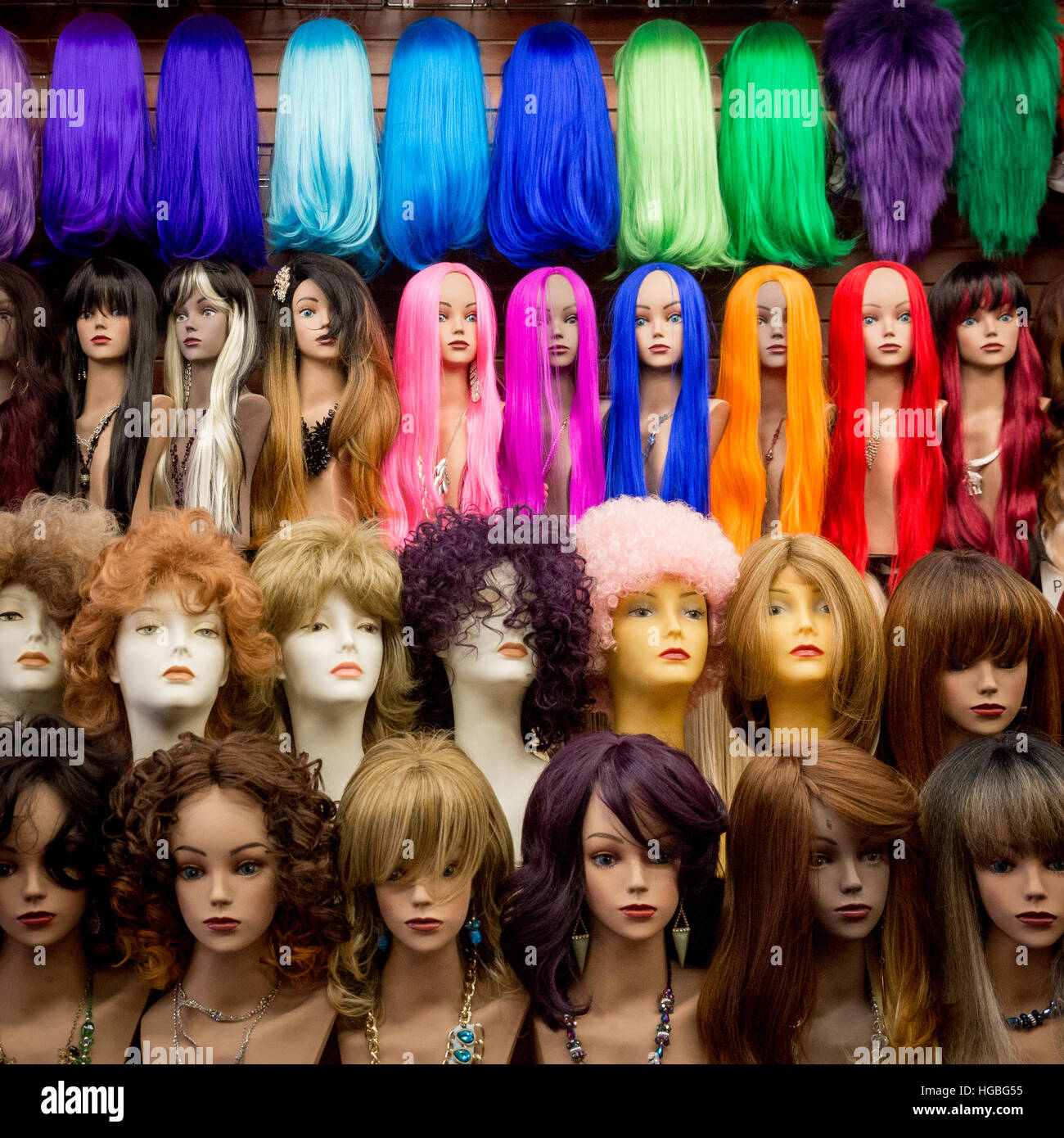 Vividly colorful wigs on mannequin heads inside a shop in the Fashion District, Los Angeles, California. Stock Photo