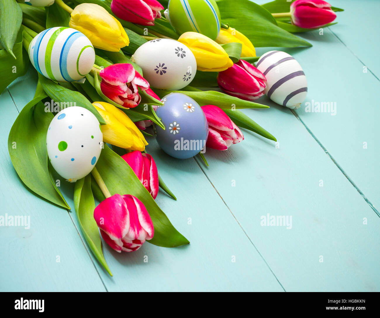 Red and yellow tulips with colorful Easter eggs Stock Photo - Alamy