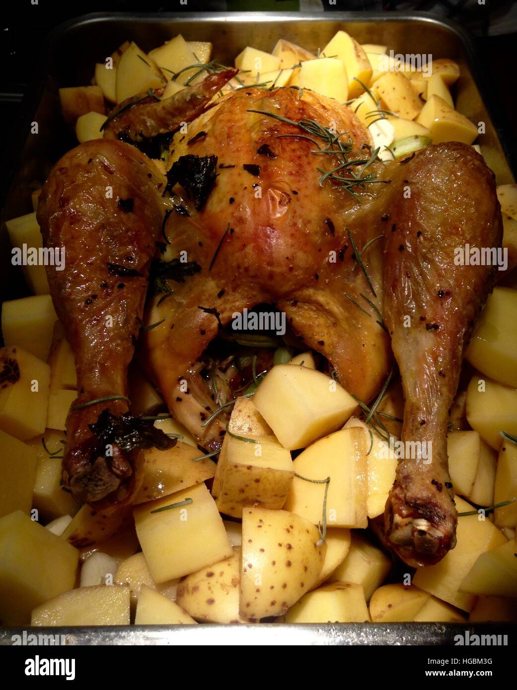 Chicken with herbs and baked potatoes Stock Photo