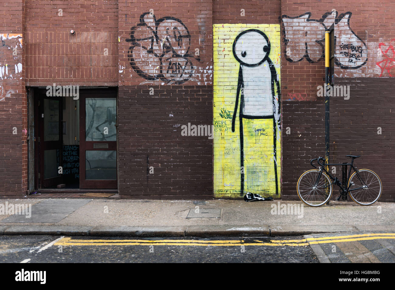 Street mural by artist Stik or a tall figure looking pensive in London Stock Photo