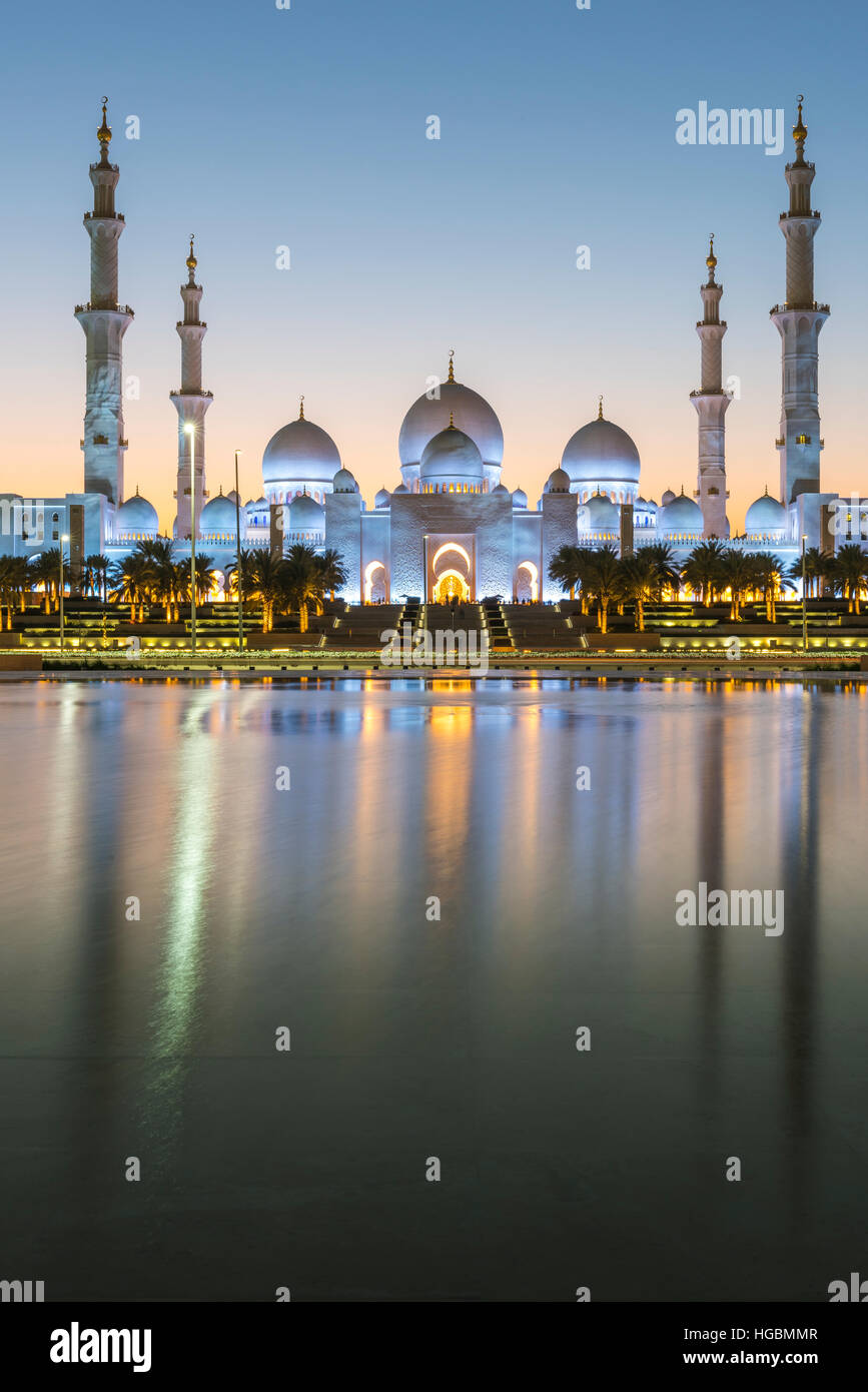 Sunset over the Sheikh Zayed Grand Mosque in Abu Dhabi, United Arab Emirates.  Mosque is built of white marble and dominates the skyline Stock Photo