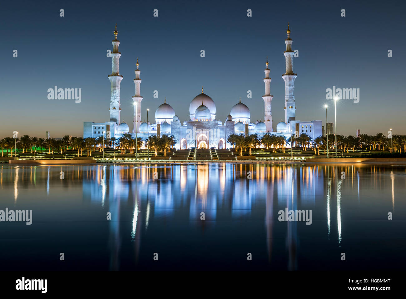 Sunset over the Sheikh Zayed Grand Mosque in Abu Dhabi, United Arab Emirates.  Mosque is built of white marble and dominates the skyline Stock Photo