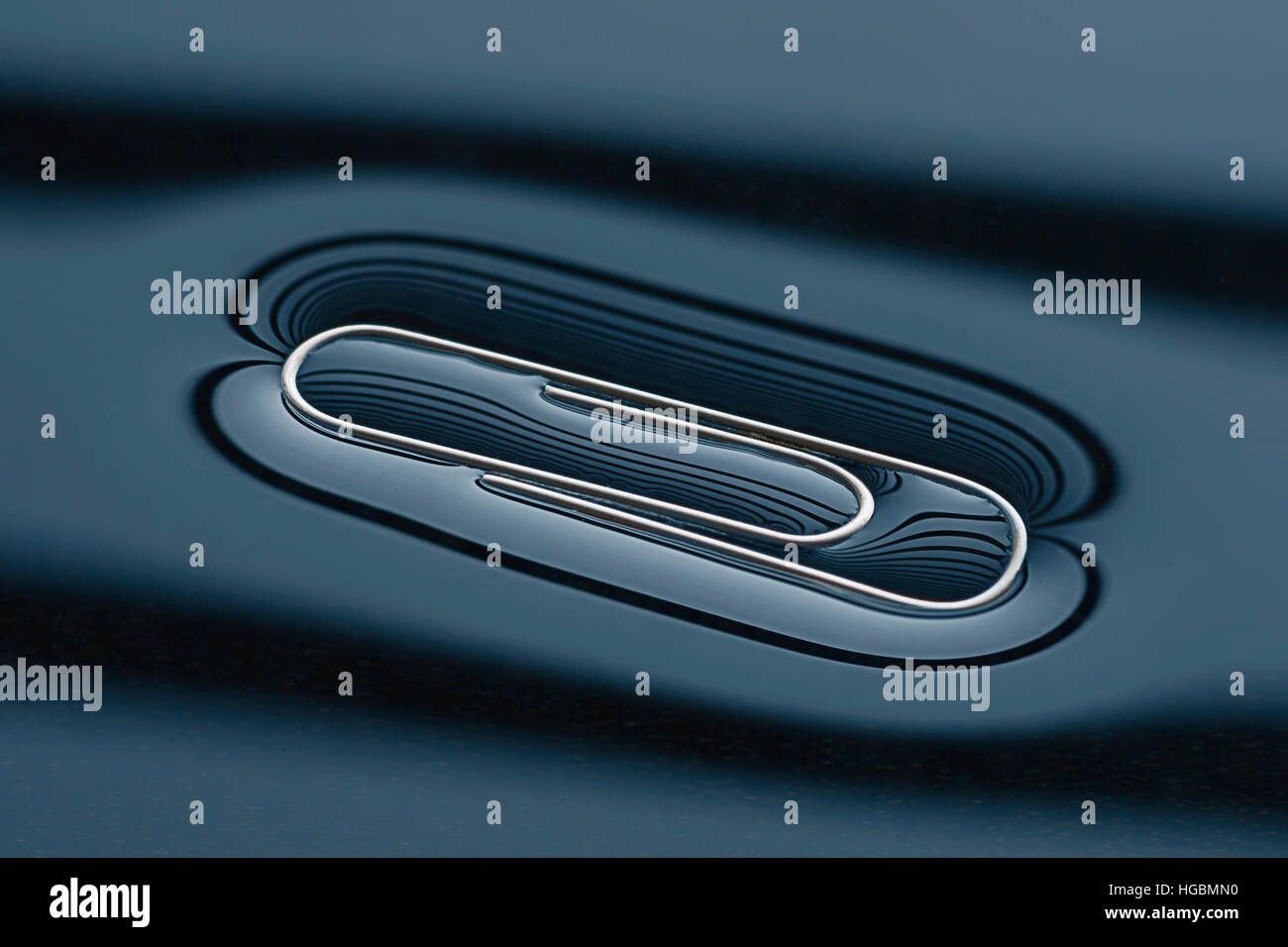 Floating Paperclip. Paper clip floating on water courtesy of surface