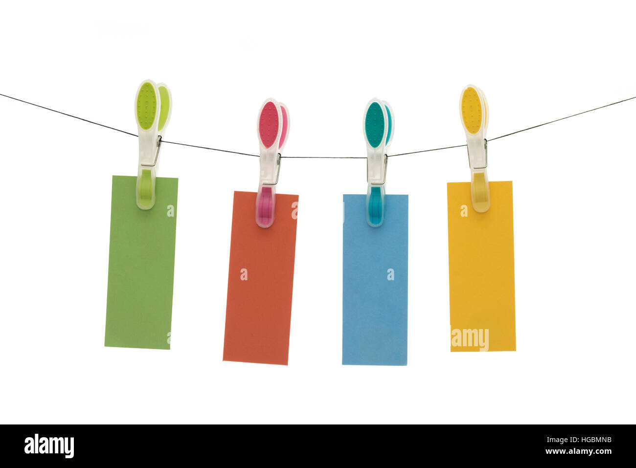 Hanging cards - four pieces of colored paper hanging from a line by clothes pegs Stock Photo