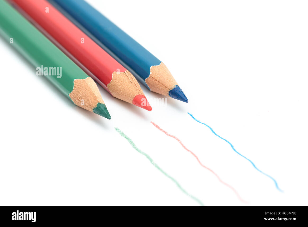 Coloring pencils. Red, green and blue coloring pencils isolated on a white sheet of paper with lines drawn by the pencil Stock Photo