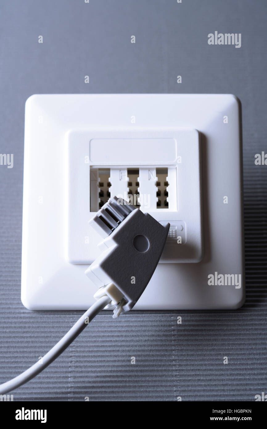 Telephone cable connecting to phone jack Stock Photo Alamy
