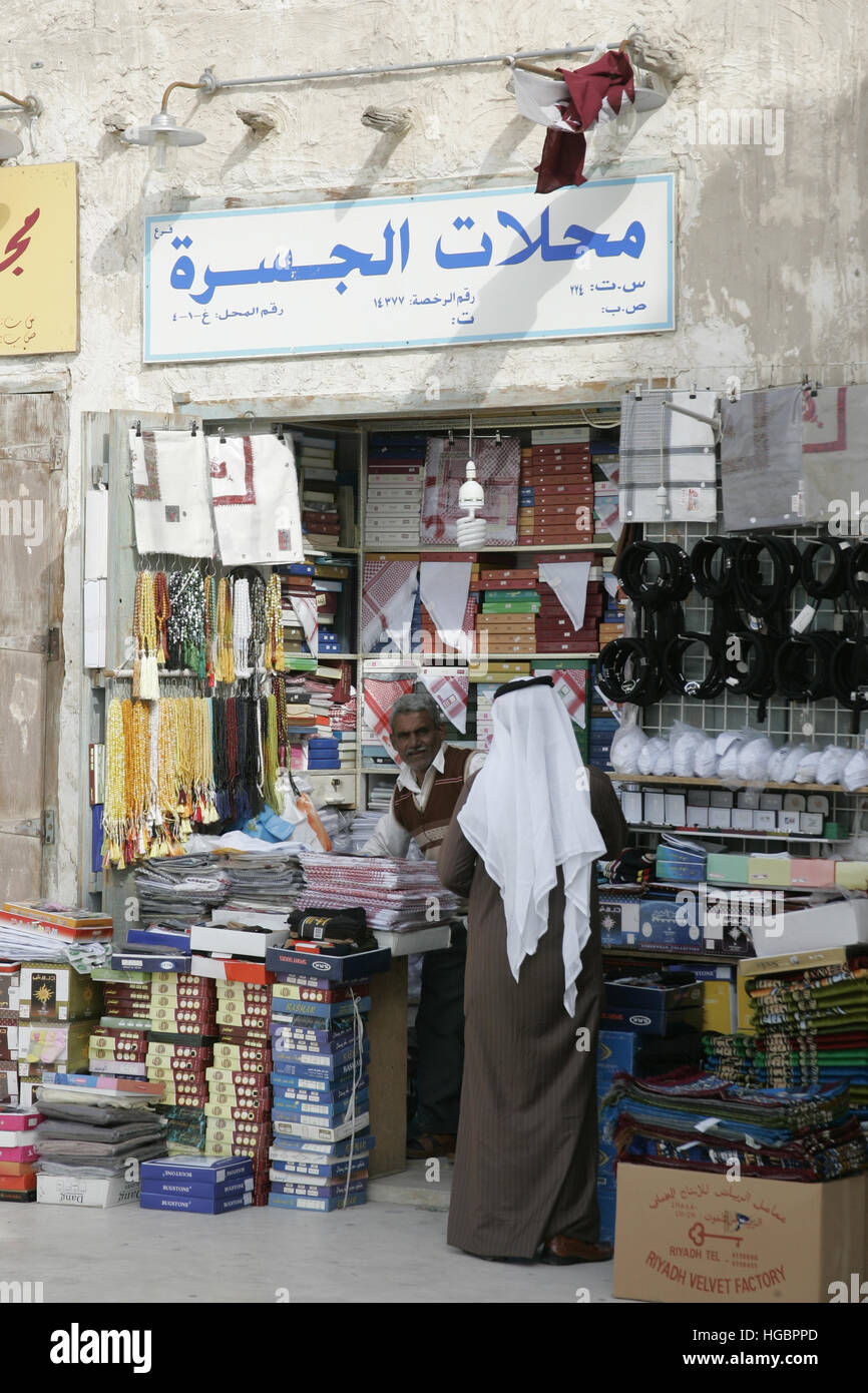 Qatar, Doha, Arabian merchant serving customer, Arab in his shop in