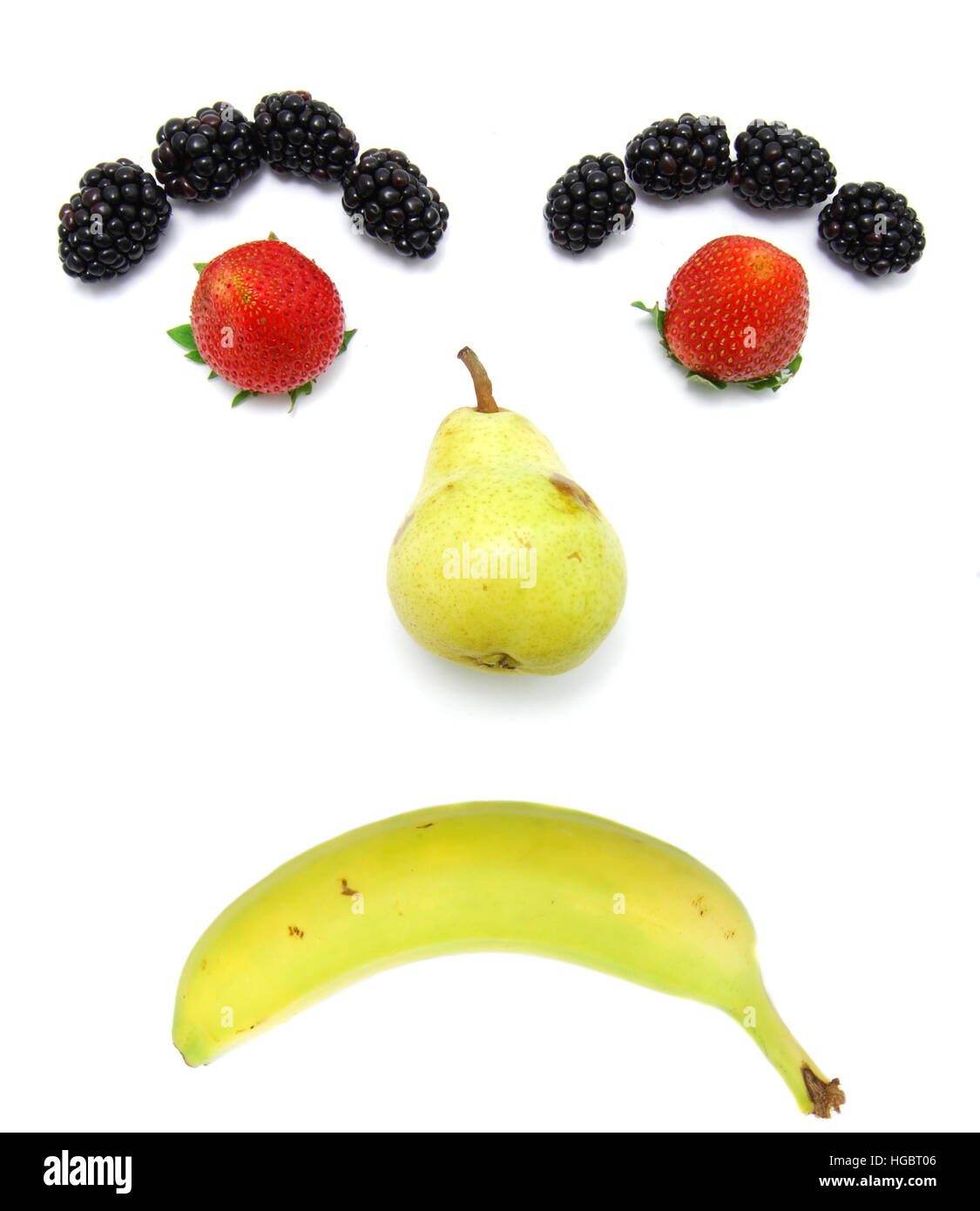 Sad Fruit Face. Kid friendly. Banana, pear, strawberry, and blackberry. Stock Photo
