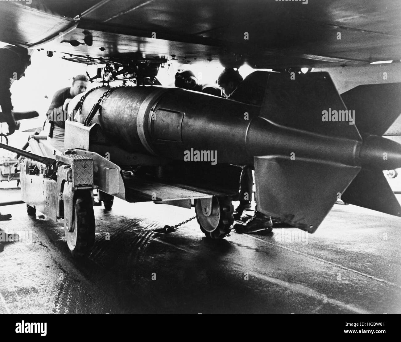 Men aboardUSS Ranger position a 2,000 pound bomb under the wing of an A-1 Skyraider, 1965. Stock Photo