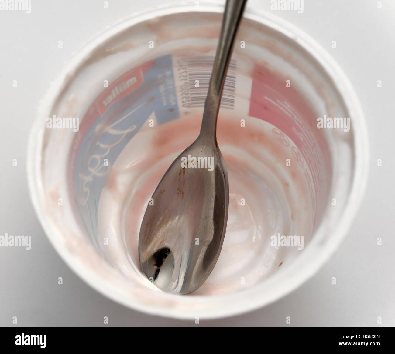 An empty yogurt pot with a spoon inside Stock Photo Alamy