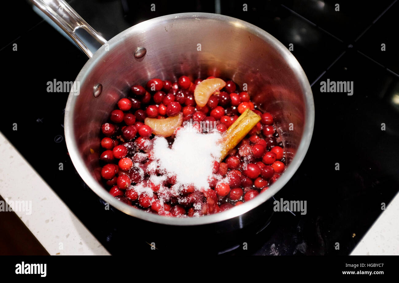 Cranberry sauce being made with cranberries sugar and cinnamon stick Stock Photo