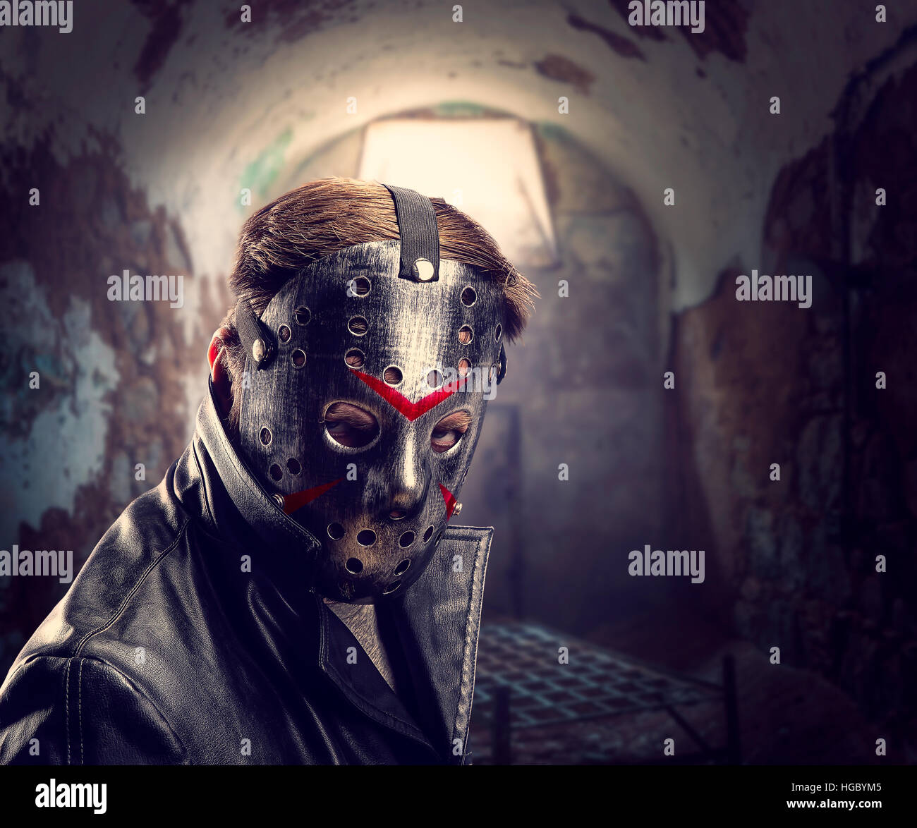 Serial maniac in hockey mask at torture chamber Stock Photo