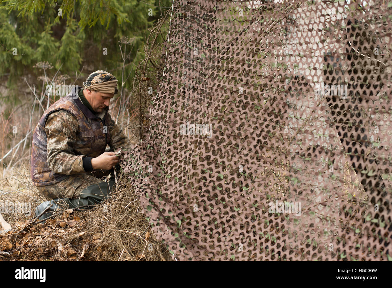 hunter and camouflage netting Stock Photo Alamy