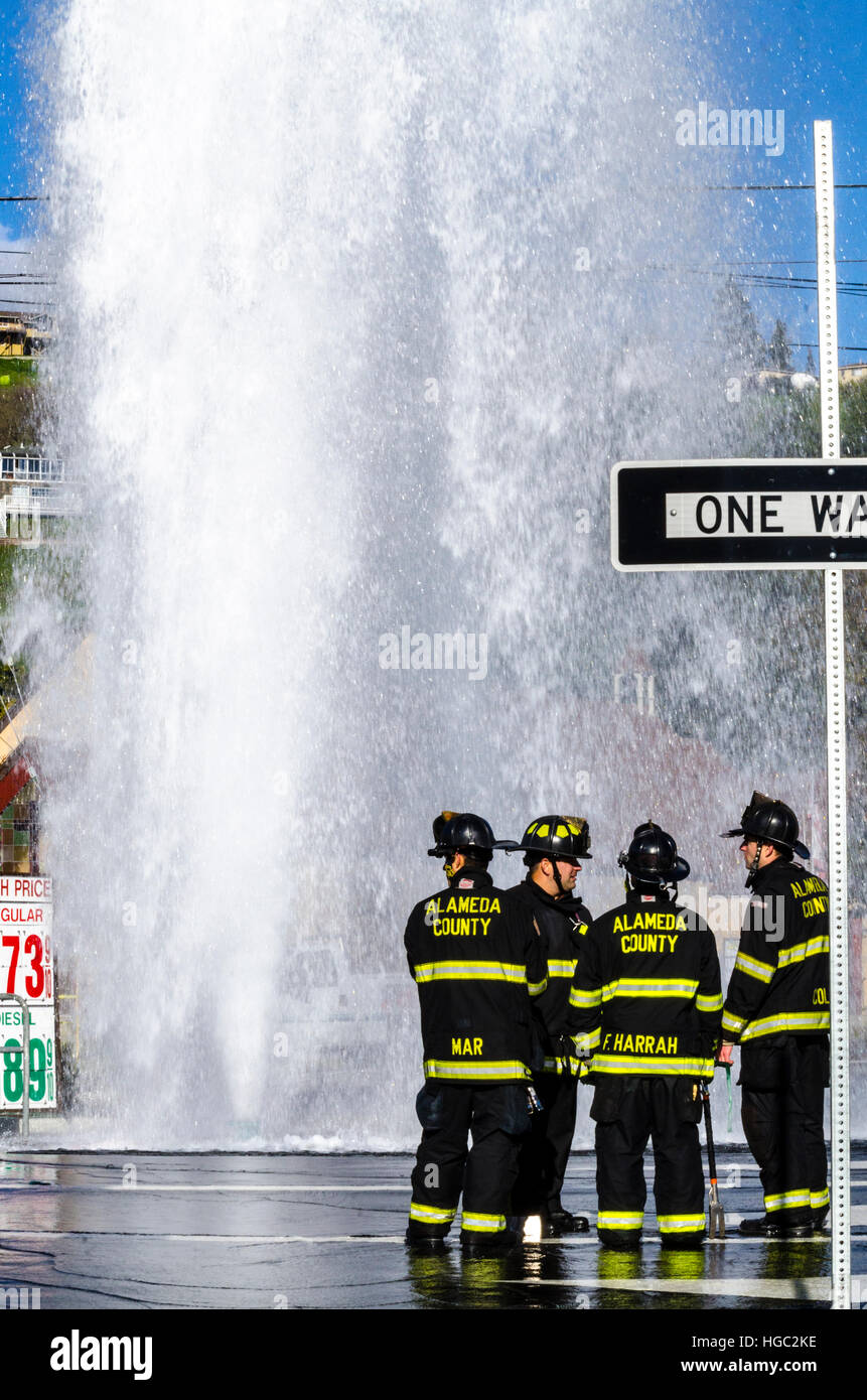 A fire hydrant broken off by a truck creates a geyser and small flood in San Leandro California Stock Photo