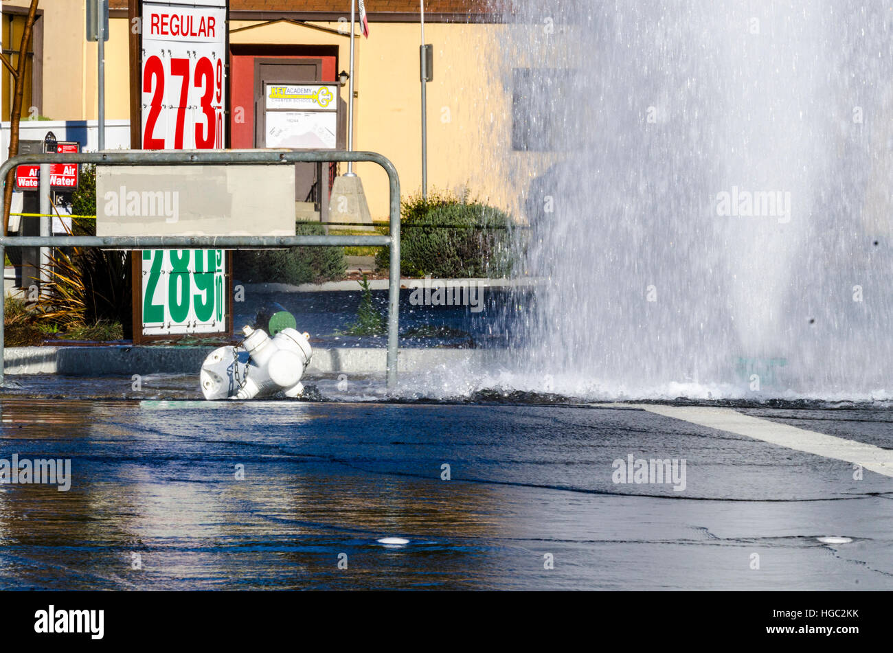 A fire hydrant broken off by a truck creates a geyser and small flood in San Leandro California Stock Photo