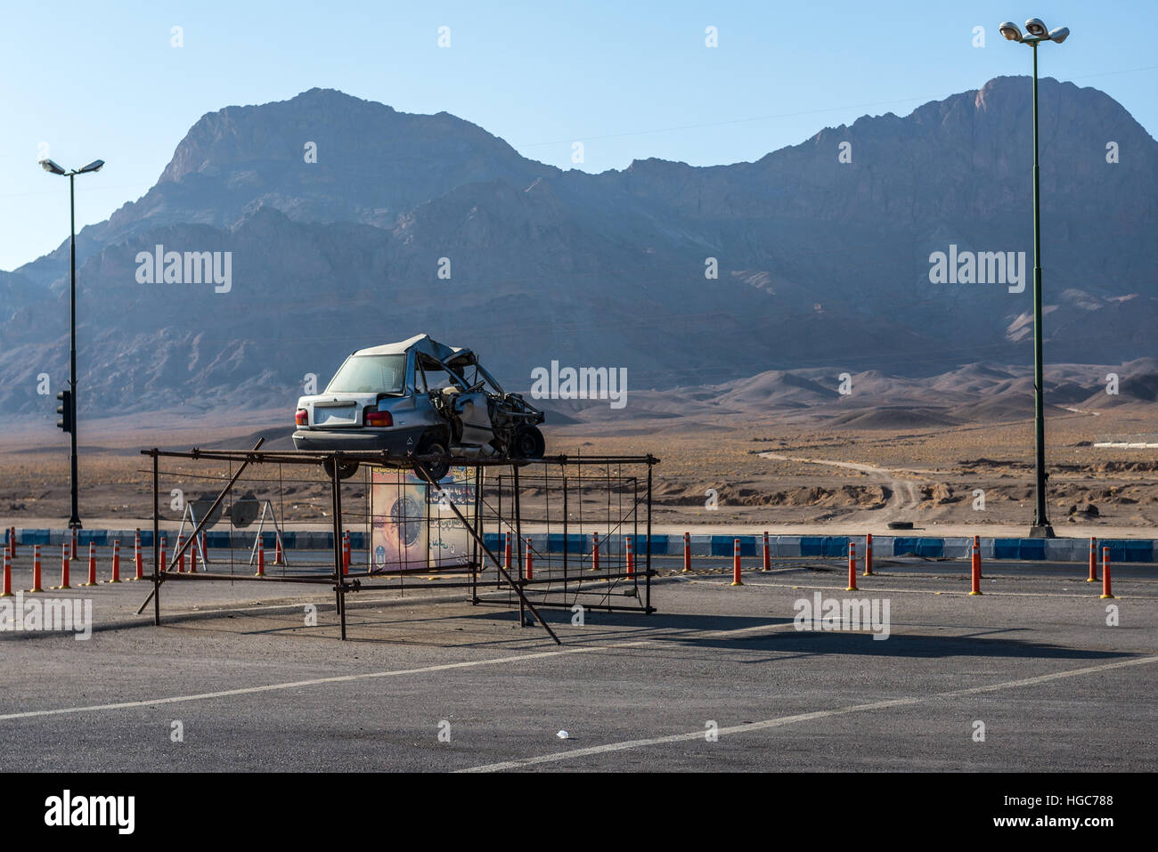 Wrecked car placed as a warning next to road in Yazd Province, Iran Stock Photo