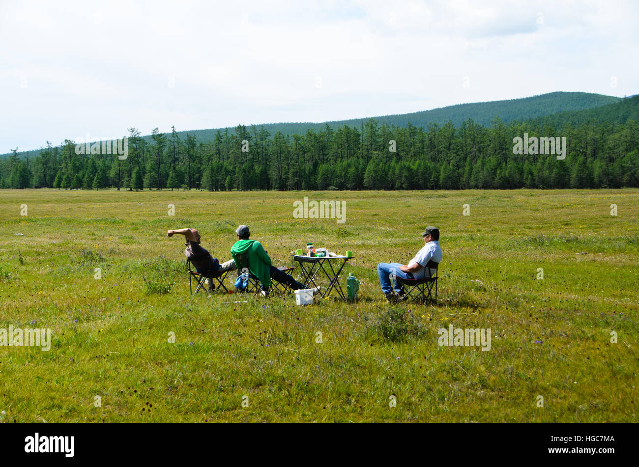 Mongolians having picnic on Taiga grassland in summer time. Stock Photo